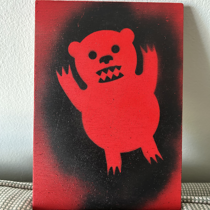 Portable bear spray-painted on a piece of wood
